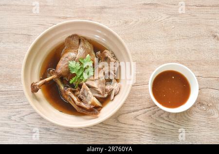 Gekochtes Entenfleisch in schwarzer Sojabohnensuppe in Schüssel, mit scharfer Chilisauce Stockfoto