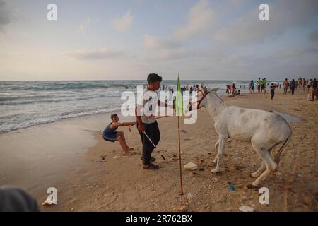 Gaza, Palästina. 13. Juni 2023. Kinder haben Spaß am Strand in Deir El Balah gesehen. Palästinensische Familien strömen zum Gazastreifen, um aufgrund der hohen Temperaturen am 11. Juni 2023 im zentralen Gazastreifen Deir al-Balah, Palästinensische Gebiete, eine Pause einzulegen. Foto: Ramez Habboub/ABACAPRESS.COM Kredit: Abaca Press/Alamy Live News Stockfoto