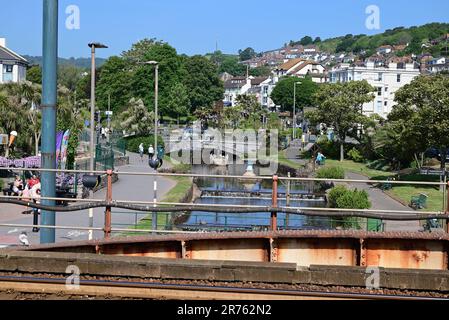 Blick auf Dawlish von der neuen Fußgängerbrücke (2023) entlang der Ufermauer am Bahnhof Dawlish. Stockfoto