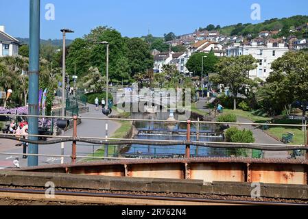 Blick auf Dawlish von der neuen Fußgängerbrücke (2023) entlang der Ufermauer am Bahnhof Dawlish. Stockfoto