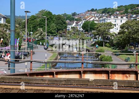 Blick auf Dawlish von der neuen Fußgängerbrücke (2023) entlang der Ufermauer am Bahnhof Dawlish. Stockfoto