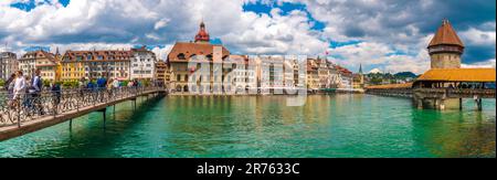 Wunderschönes, riesiges Panoramabild von Luzerns Altstadtboulevard am Fluss Reuss mit Menschen auf der Brücke Rathaussteg und der berühmten Kapellbrücke... Stockfoto