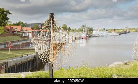 Schwarzes Kreuz mit einem Fischernetz im Hafen von Greetsiel als stummer Protest der Fischer gegen ein geplantes Verbot von Grundschleppnetzen Stockfoto