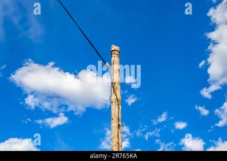 Elektrischer Strommast mit Liniendraht auf farbigem Hintergrund in Nahaufnahme, Fotografie bestehend aus elektrischem Strommast mit Liniendraht unter Himmel, Liniendraht i Stockfoto