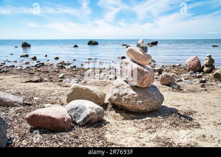 Steinpyramide an der Ostsee mit Blick auf das Meer mit blauem Himmel und Sonnenschein. Spirituelle Sichtweise. Landschaftsaufnahmen von Poel Island Stockfoto