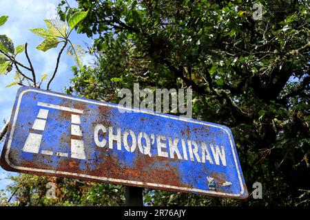 Ein blaues metallisches Straßenschild mit dem Namen „Choquequirao“ vor dem Hintergrund von üppigem Grün Stockfoto