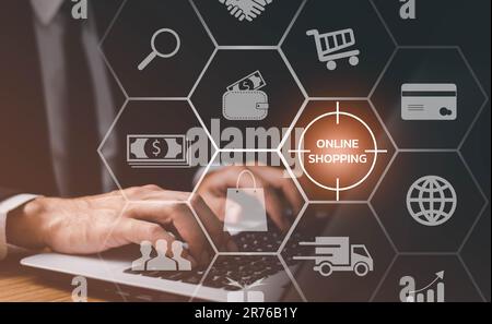 Geschäftsmann, der ein Notebook mit Warenkorbsymbol, Online-Shopping und E-Commerce-Konzept verwendet. Stockfoto