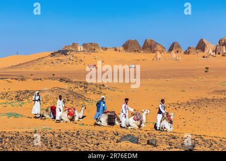 Traditionell gekleidete araber mit ihren Kamelen warten auf Touristen an den nubischen Pyramiden in meroe im sudan Stockfoto