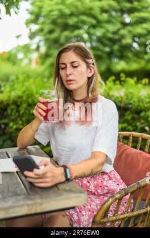 Süße Frau, die im Sommergarten Tee trinkt Stockfoto