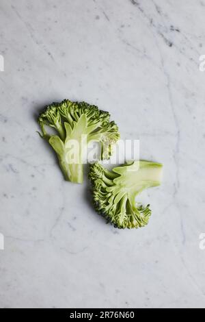 Grüne Brokkolistämme von oben auf grauem Hintergrund Stockfoto