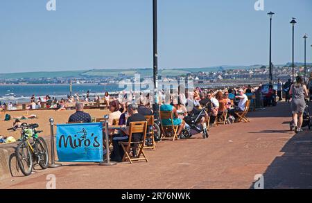 Portobello, Edinburgh, Schottland, Großbritannien. 13. Juni 2023 Am Porty Beach ist es heiß und die Promenade für die gemischten Menschenmassen am späten Nachmittag nach einem weiteren nebligen Start in den Tag. Temperatur 21 Grad Celsius mit einer kühlen Brise. Abbildung: Menschen jeden Alters, die sich im Café-Restaurant auf der PromenadeCredit: Arch White/alamy Live News entspannen. Stockfoto