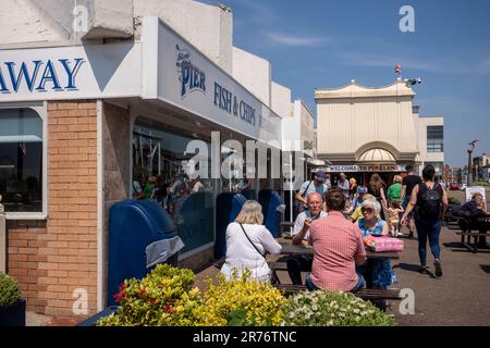 Southport, Merseyside, an einem warmen und sonnigen Tag. Leute essen Fish & Chips. Stockfoto