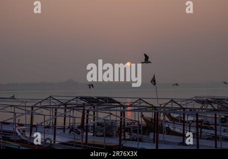 Varanasi: Bootsfahrt in Varanasi, Holzboote, die bei Sonnenaufgang am ganges-Ufer geparkt haben. Touristen benutzten Boote, um den Fluss zu überqueren und um sich die Stadt anzusehen. Stockfoto