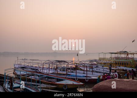 Varanasi: Bootsfahrt in Varanasi, Holzboote, die bei Sonnenaufgang am ganges-Ufer geparkt haben. Touristen benutzten Boote, um den Fluss zu überqueren und um sich die Stadt anzusehen. Stockfoto
