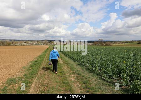 Eine Frau läuft ohne Schuhe auf einer unbefestigten Straße Stockfoto