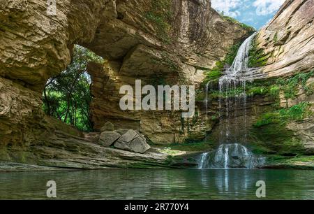 Ein großer, schöner Wasserfall inmitten von Felsen. Naturhintergrund. Stockfoto