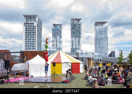 Die Akrobatikshow der Blind gut Company mit Hochhäusern im Hintergrund im Stadtteil Kalasatama in Helsinki, Finnland Stockfoto