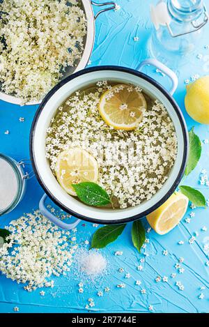 Herstellung eines Sommergetränks, hergestellt aus der natürlichen Gärung älterer Blüten in Wasserzitrone und Zucker. Herstellung eines Altenblumensirups aus Stockfoto