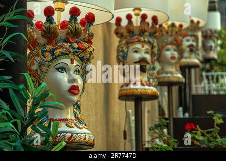 Traditionelle und handgefertigte Keramik in Form von Köpfen und handbemalten Puppen in den Geschäften und auf den Straßen der Touristenstadt Taormina Stockfoto