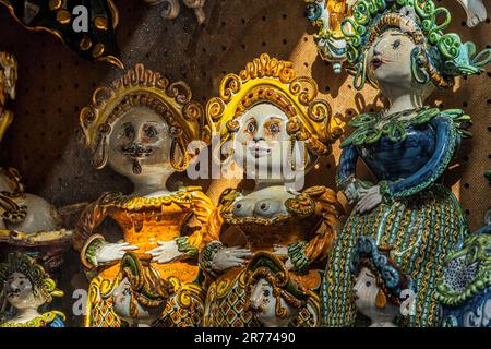 Traditionelle und handgefertigte Keramik in Form von Köpfen und handbemalten Puppen in den Geschäften und auf den Straßen der Touristenstadt Taormina Stockfoto