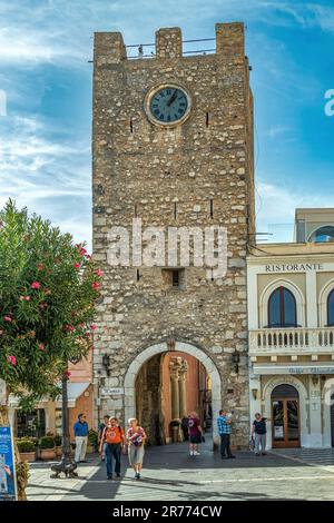 Uhrenturm und mittlere Tür, einer der Eingänge entlang des Hauptkurses der Touristenstadt Taormina. Taormina, Provinz Messina, Sizilien, Italien Stockfoto