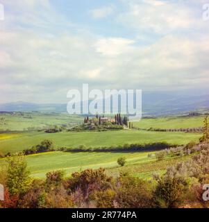 Blick auf ein Bauernhaus auf einem Hügel im Orcia-Tal in der Nähe von San Quirico d'Orcia, aufgenommen mit Analague-Filmtechnik Stockfoto