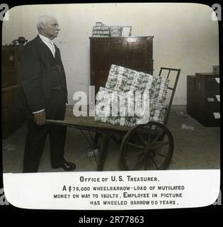 Büro des US-Finanzministeriums. Eine Schubkarren-Ladung verstümmelten Geldes im Wert von $75.000 Dollar auf dem Weg in die Tresore. Der Angestellte auf dem Foto hat seit 50 Jahren mit dem Schubkarren gefahren. Fotografien des Personals, der Einrichtungen und Aktivitäten des Finanzministeriums. Finanzministerium Stockfoto