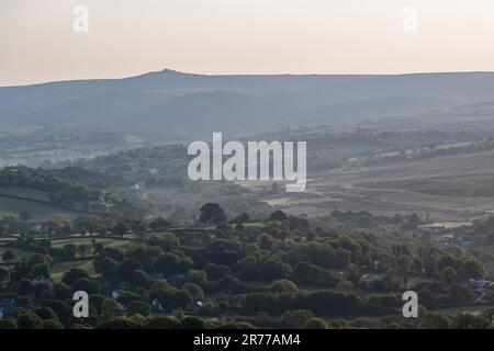 Vom Brent Tor Hill aus blickt man in Richtung Nordosten. Die Dämmerung um Brentor und Lydford in West Devon fällt auf die Landschaft, mit Great Links Tor auf Dartmoor Stockfoto