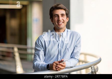 Porträt eines glücklichen jungen Mannes mit Smartphone, Outdoor-Aufnahme Stockfoto