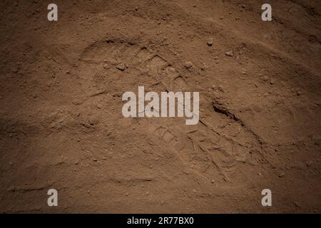 Fußabdruck eines Stiefels in einem roten Sand, der wie die Oberfläche oder der Mars aussieht oder die Oberfläche eines Planeten erforscht Stockfoto