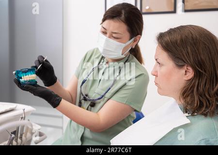 Der Fachzahnarzt prüft die Zähne des Patienten und erklärt die Verfahren in der Praxis des Zahnarztes Stockfoto