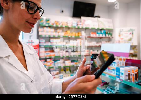 Eine Apothekerin prüft Informationen zu Arzneimitteln auf der Tablette Stockfoto