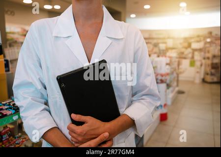 Eine Apothekerin prüft Informationen zu Arzneimitteln auf der Tablette Stockfoto
