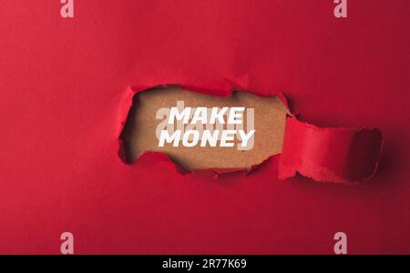 Text auf dem Hintergrund von rotem Papier mit einem Loch macht Geld Stockfoto