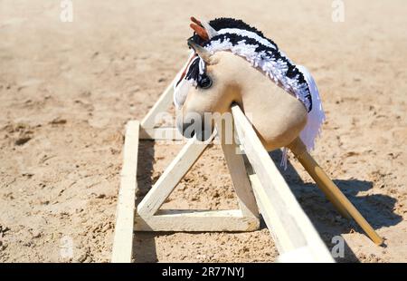 Drei Hobbypferde warten auf die Reiter. Reitsport. Reitausrüstung. Sport. Sommer. Die Sonne. Banner. Im Freien. Nahaufnahme Stockfoto