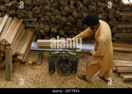 12. Juni 2023, Srinagar Kaschmir, Indien : Ein Arbeiter plant Planks für GR8 Cricket-Fledermäuse in einer Produktionsstätte in Sangam, etwa 38 Kilometer südlich von Srinagar. Die Fledermaushersteller in Kaschmir haben einen Auftrag für die Verwendung von Fledermäusen während der One Day International (ODI) Weltmeisterschaft 2023 erhalten; noch früher hatten sie für die Weltmeisterschaft Twenty20 (T20) im Jahr 2022 10 Fledermäuse bestellt. Weltweit werden nur zwei Arten von Fledermäusen im Cricket verwendet - englische Willow und Kashmiri Willow - und während die Preise für englische Willow um ein Vielfaches höher sind als die aus Kaschmir Willow und von häufiger verwendet werden Stockfoto