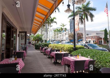 Leere Restauranttische im Freien während der Hochsaison auf dem Bürgersteig auf der 5. Avenue South in Naples, Florida, USA. Stockfoto