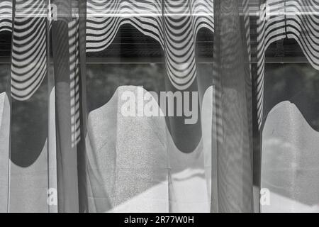 Abstraktes Muster aus Fensterläden und transparenten Vorhängen Stockfoto