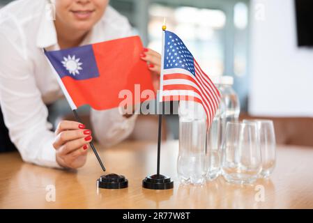 Bürokoordinator setzt Flaggen von Taiwan und den Vereinigten Staaten auf den Tisch Stockfoto