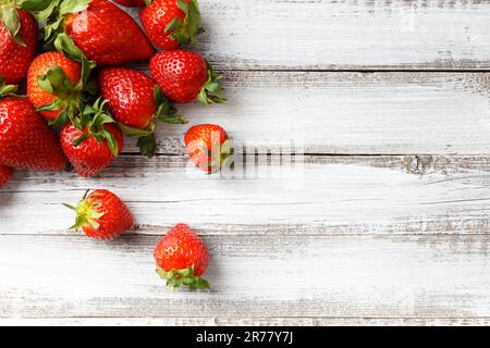 Beeren großer reifer, frischer biologischer Erdbeeren auf Holzhintergrund, Nahaufnahme, Draufsicht, mit Platz für Text. Stockfoto