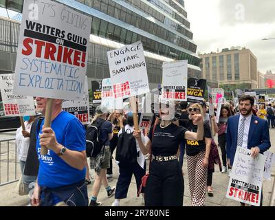 Mitglieder der Writers Guild of America East und andere Gewerkschaftsanhänger klettern am Montag, den 12. Juni 2023 vor den HBO/Amazon-Büros im Viertel Hudson Yards in New York. Die Autoren wünschen sich einen größeren Anteil am Streamingumsatz sowie obligatorische Personalausstattung und Beschäftigungsdauer. Der letzte Streik im November 2007 dauerte 100 Tage. (© Frances M. Roberts) Stockfoto