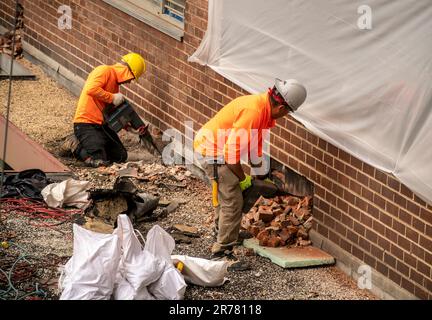 Arbeiter führen am Montag, den 12. Juni 2023, im Auftrag der Stadt Fassadenreparaturen an der Außenseite eines Apartmenthauses in Chelsea in New York durch (© Richard B. Levine) Stockfoto