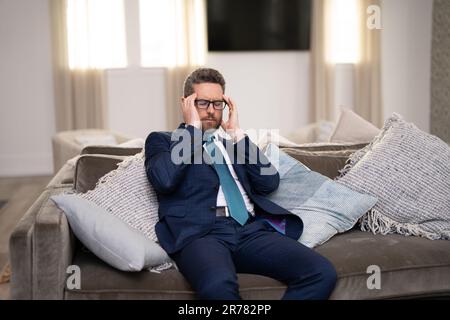 Müder Mann fühlt Schmerzen, wenn er die Brille festhält, trockene gereizte Augen ermüdet von der Computerarbeit, gestresster Mann leidet an Kopfschmerzen, Sehstörungen Stockfoto