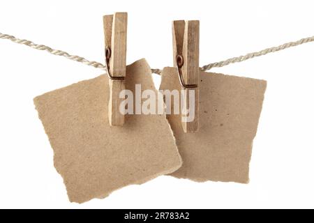 Haftnotizen auf grobem Papier hängen auf Holzkaschentücher an einem geflochtenen Seil. Platz für eine Inschrift Stockfoto