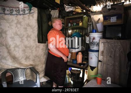 Nairobi, Kenia. 12. Juni 2023. Josephine Achando, eine fünfköpfige Mutter, die ihr Haus in Kibera Slum aufräumte. Josephine Achando, ein 35-jähriger Albino, eine fünfjährige Mutter lebt mit ihren fünf Kindern, einschließlich ihres Mannes, der als Wachmann arbeitet, am Stadtrand von Langata Village in Kibera Slum. Josephine lebt seit ihrem letzten Job im Jahr 2008 arbeitslos, während sie als Putzfrau arbeitet. Als arbeitslose Mutter mit Kindern und grundlegenden Familienbedürfnissen verkauft sie geröstete Erdnüsse für das Überleben der Familie, da das Einkommen ihres Mannes nie ausreicht, um alle Bedürfnisse der Familie zu befriedigen. Sie konnte es nicht Stockfoto