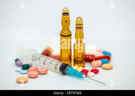 Sammlung von Arzneimitteln, Pillen, Kapseln, Ampullen und einer Spritze mit Nadel. Stockfoto