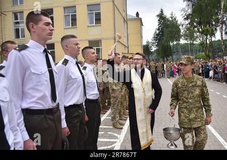 10. Juni 2023, Lemberg, Ukraine: Ein Priester streut Kadetten mit Weihwasser während der Abschlusszeremonie im Heroes Krut Lyceum in Lemv Heroes Krut Lyceum verbesserte das militärische Übungstraining und sie feierten ihre 147. Graduierung der Kadetten. Dieses Lyceum ist eine einzigartige spezialisierte Einrichtung der Sekundarstufe II-III des militärischen Profils für die Bildung von Kindern ab dem Alter von 13 Jahren. Sie ist das primäre Bindeglied des militärischen Bildungssystems der Ukraine, da ihre Absolventen zu Kadetten von höheren militärischen Bildungseinrichtungen der Strukturen der Sicherheit und der de werden Stockfoto