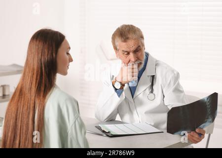 Der Orthopäde zeigt dem Patienten in der Klinik das Röntgenbild Stockfoto