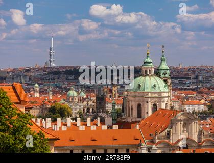 PRAG, TSCHECHISCHE REPUBLIK, EUROPA - ST. Nicholas-Kirche, eine barocke Kirche in der Kleinseite von Prag, und Blick auf die Stadt. Zizkov Fernsehturm in der Ferne. Stockfoto