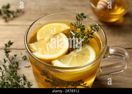 Frischer Thymiantee mit Zitronenstückchen auf dem Tisch, Nahaufnahme Stockfoto